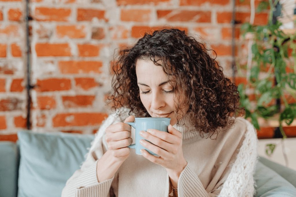 A photo of a woman smelling a drink