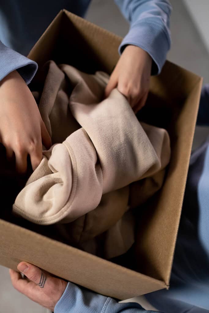 a person putting clothes in the box
