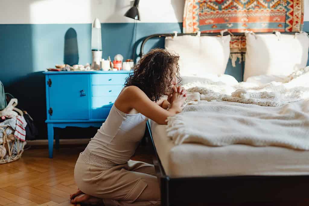 a woman silently praying in her bedroom