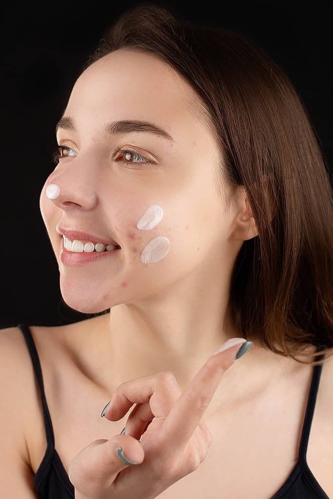 a woman putting cream on her face
