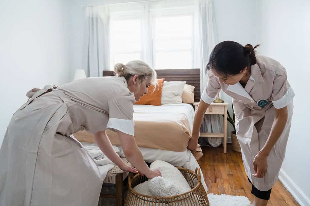 two women putting a dirty pillow on the basket