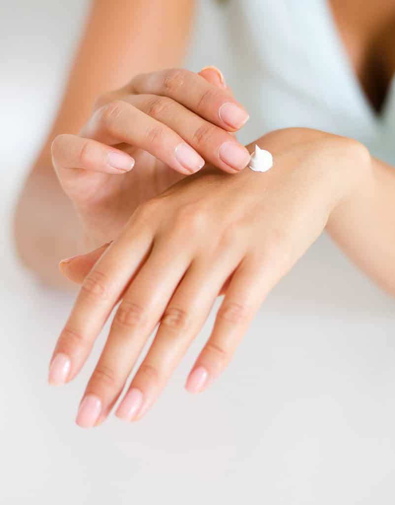 a person putting cream on their hand