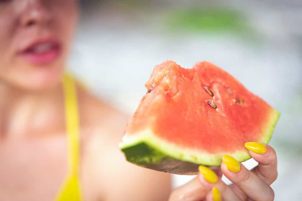 a woman holding a watermelon