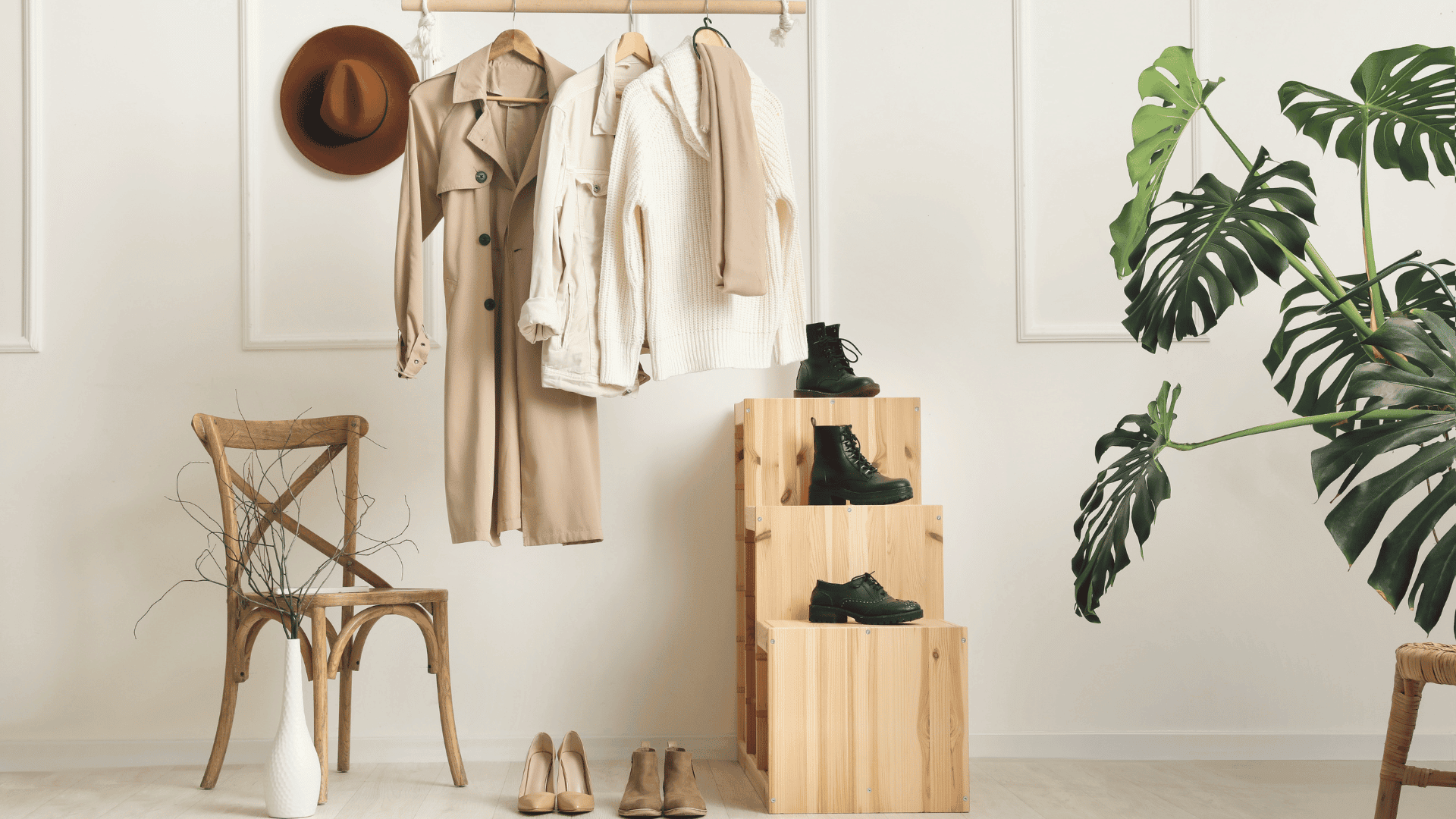 AN Overlay Template - 2025-09-23T155236.820 Classic old money style wardrobe with beige trench coat, cream knit sweater, neutral shoes, and black boots, styled in a minimal elegant interior.