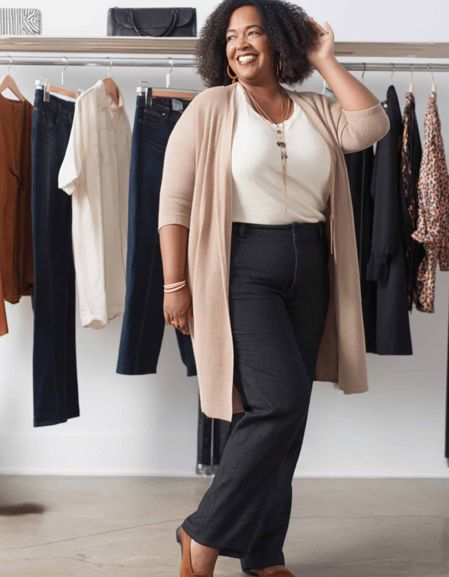 A lady standing in front of clothes in a boutique A lady standing in front of clothes in a boutique