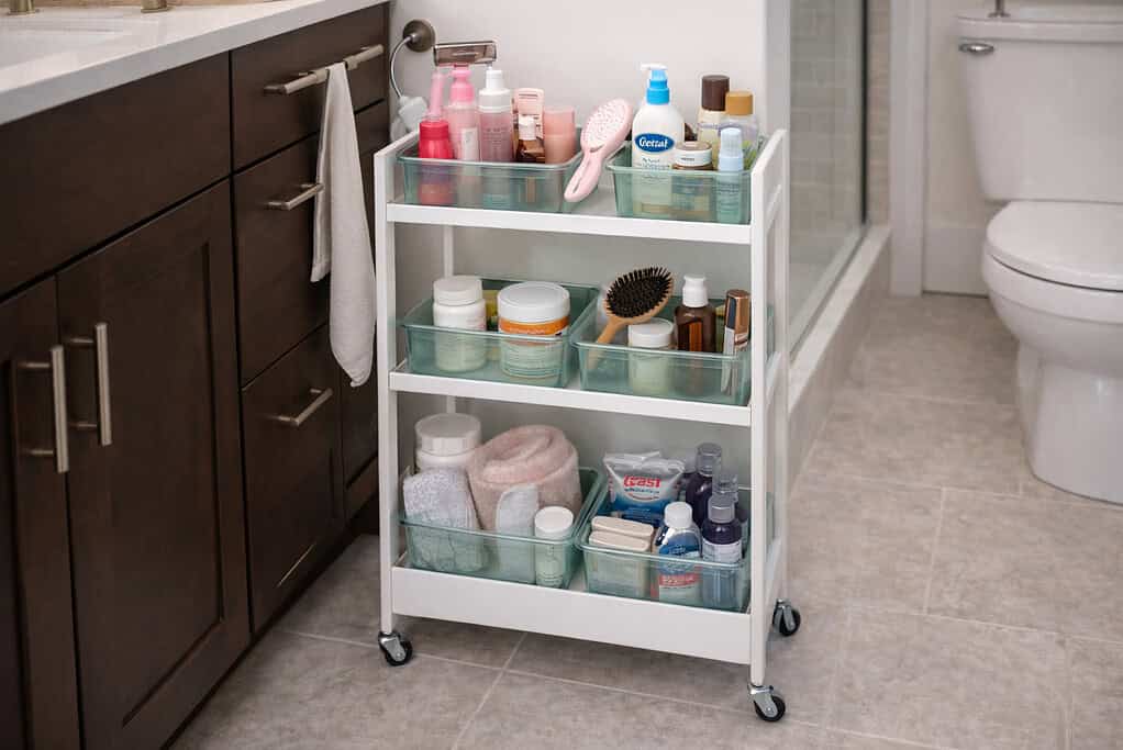 An organized bathroom with rolling storage cart