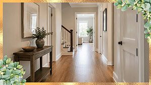A clean and clear home hallway with bare hardwood floors and nothing on the ground in bright natural light