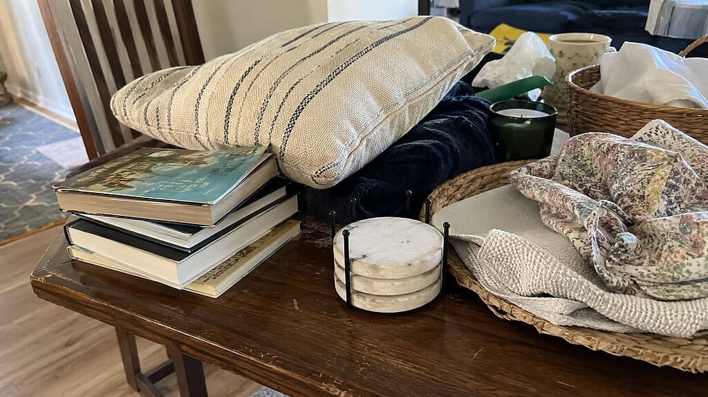 A small pile of in-between items like coasters, a throw pillow, and finished books, the kind you're unsure whether to keep when decluttering