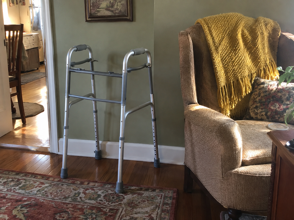 A barely-used folding walker in good condition standing in an ordinary home, still useful but no longer needed