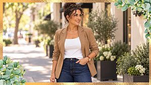 Woman in her fifties with curly hair wearing dark wide-leg jeans, a white top, and an open camel blazer on a bright street, with open space for a title.