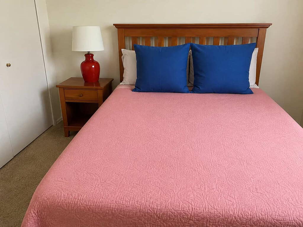 A perfectly made bed with tight corners in a tidy bedroom, the immaculate-home standard perfectionism comes from