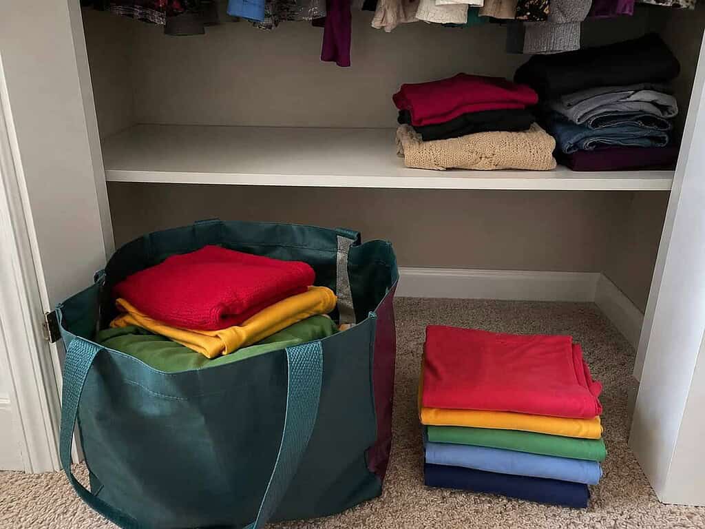 One partly filled donation bag beside a half-cleared closet shelf, the small imperfect start that finally works