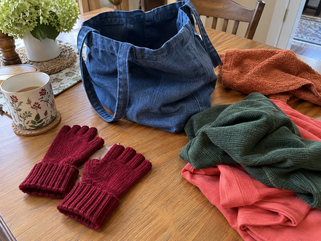 Soft fingerless gloves, a light cloth tote, and loose piles set out to keep decluttering easy on sore hands