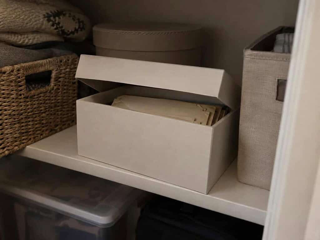 A simple archival box of old letters stored safely on a cool interior closet shelf, away from attic heat