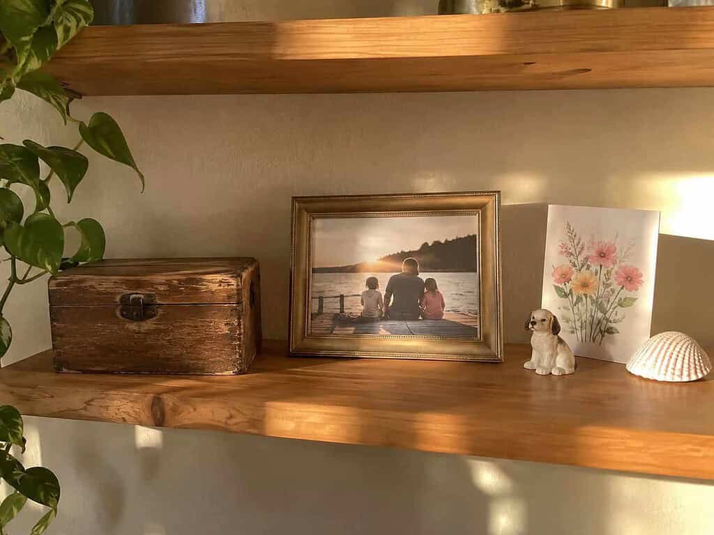 One shelf holding a few chosen keepsakes, including a worn recipe box, a family photo, and an anniversary card