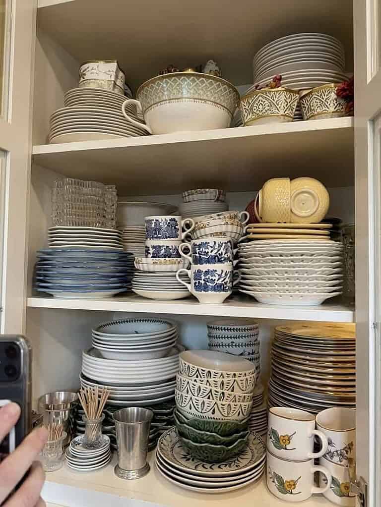 A cabinet of boldly patterned holiday dishes, the kind of sentimental belongings that start to feel like company