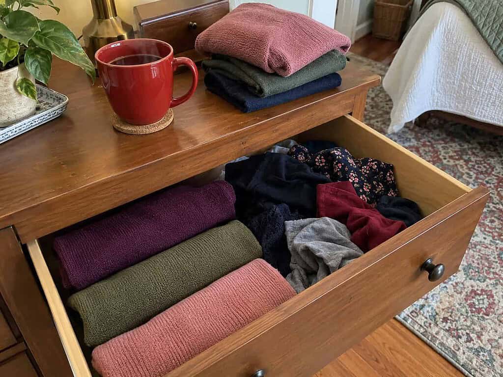 One small drawer being tidied gently with a cup of tea nearby, the unhurried pace of slow decluttering