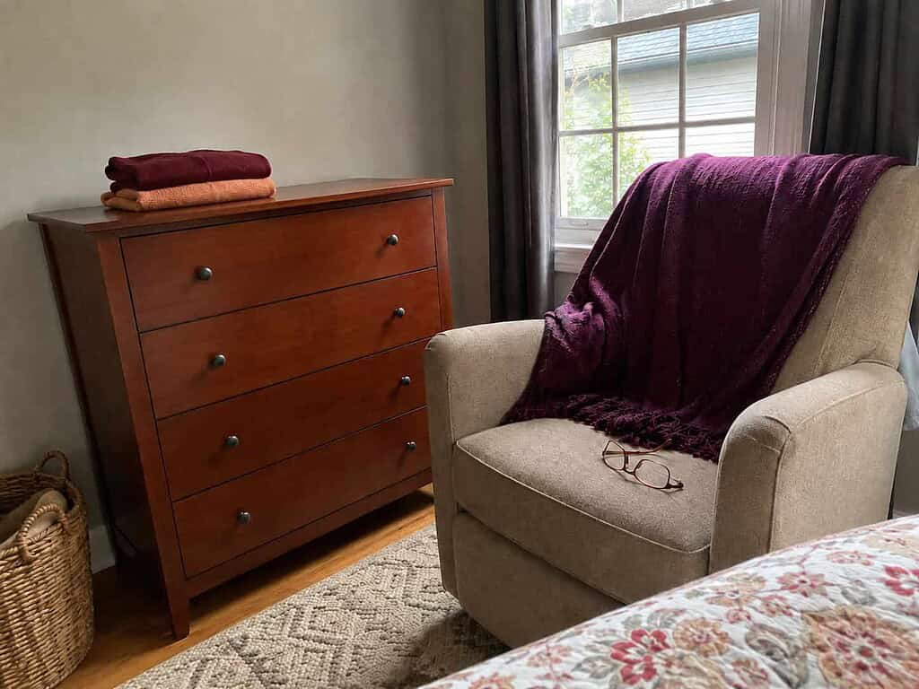 A neatly finished drawer left with a cozy chair and tea waiting, the stop-while-you-still-feel-good idea in slow decluttering