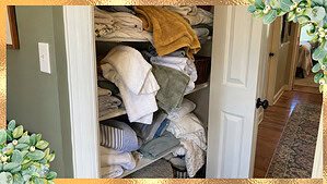 An overstuffed linen closet with folded towels and sheets spilling off the shelves, the sign of too many towels and linens