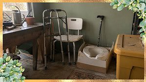 A garage corner with a used walker, shower chair, and spare cane set aside, the kind of medical equipment you can donate