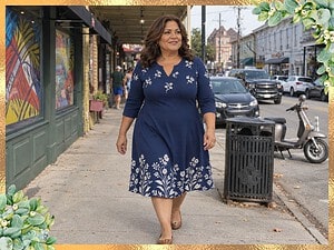 Plus size woman in a navy floral fit-and-flare dress walking on Magazine Street in New Orleans